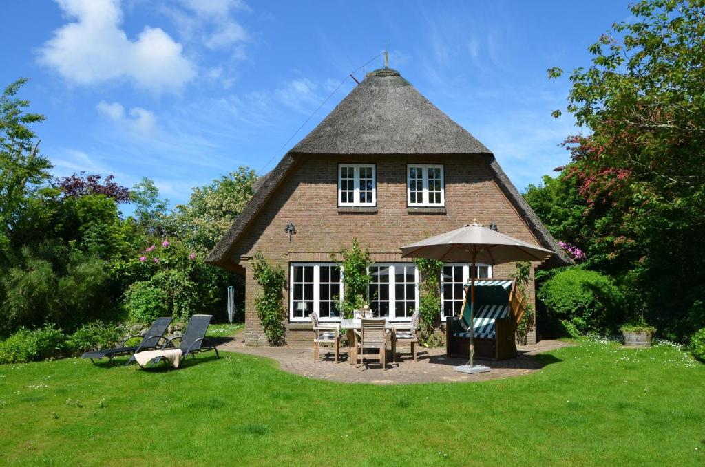 un edificio con tavolo, sedie e ombrellone di LITZKOW 14204 a Morsum