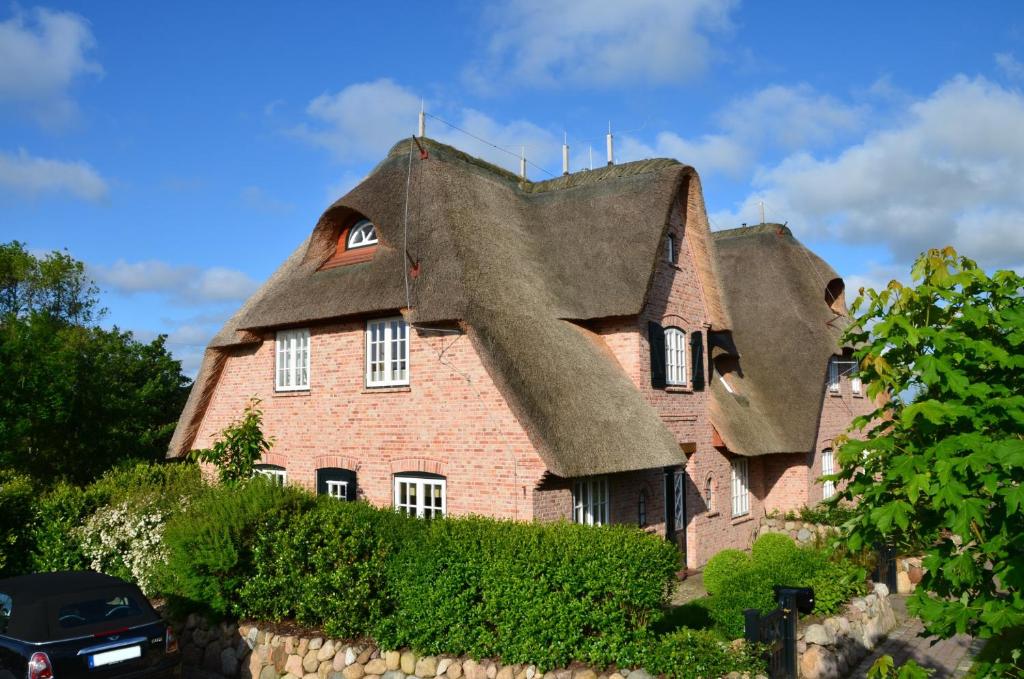 a house with a thatched roof on top of it at LITZKOW 15001 in Morsum