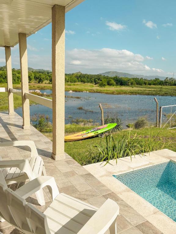 a house with a pool and a kayak in the water at Cabañas Titina's Lake in Potrero de Garay