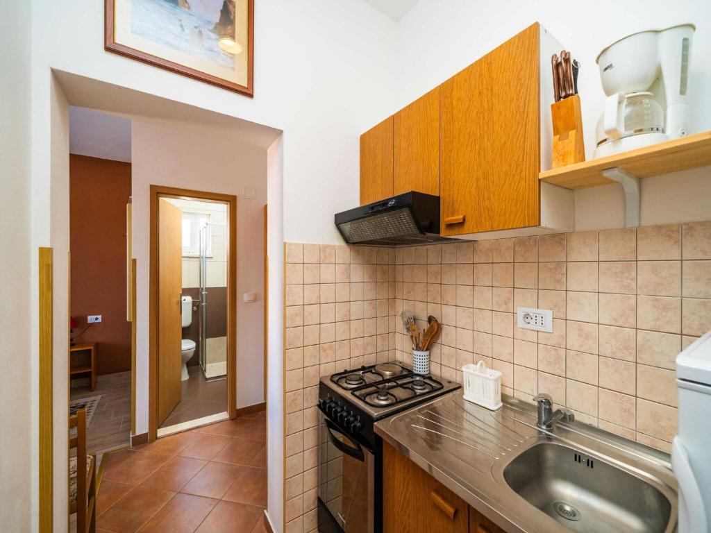 a small kitchen with a stove and a sink at Apartments Senjo - Studio Apartment with Balcony and Sea View Apartman 2 in Cavtat