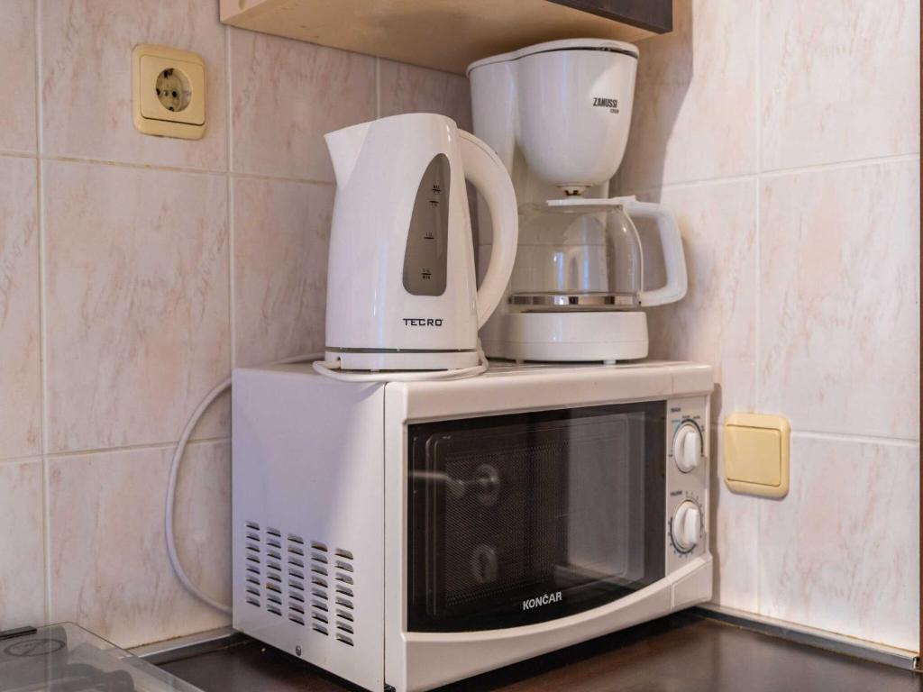 a microwave with several appliances on top of it at Apartments Senjo - Studio Apartment with Balcony with Side Sea View Apartman 4 in Cavtat