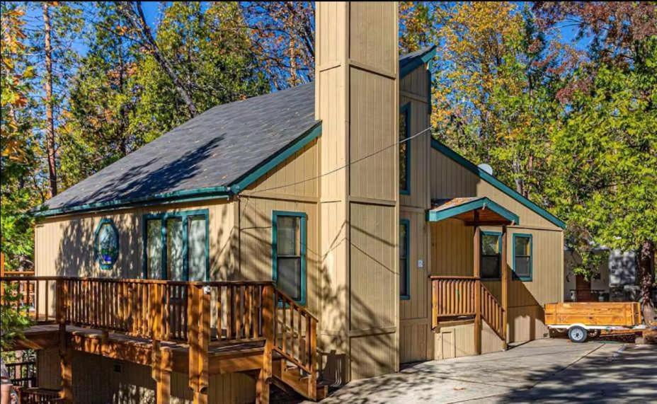 a large house with a porch and a tower at SunRidge at Willow Cove in Bass Lake