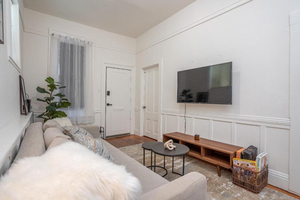 Una sala de estar con un sofá y un televisor en una pared. en Hayes Valley Home 3Bed by Restaurants, Bars and Shops, en San Francisco