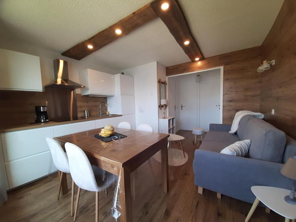 un salon avec une table et un canapé bleu dans l'établissement Apartment Renovated Cosy 6 pers, à Les Deux Alpes