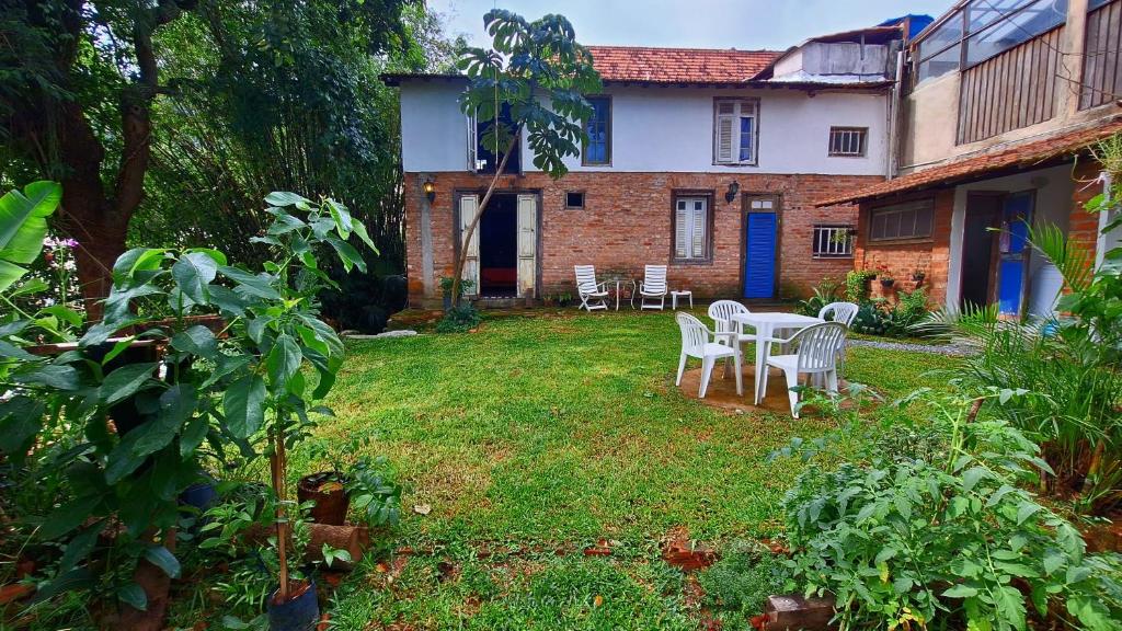 une cour avec une table et des chaises devant une maison dans l'établissement Casa em meio a natureza - Ideal para casal, à Rio de Janeiro