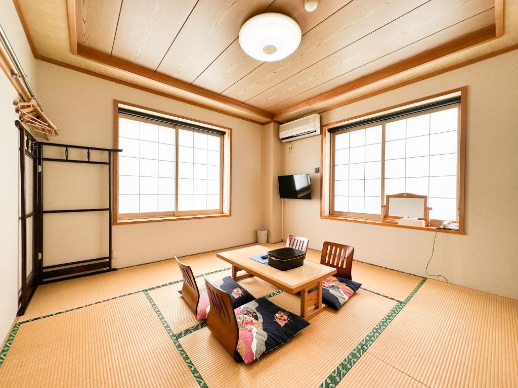 野沢温泉村にあるパール吉越のテーブルと椅子と窓のある部屋