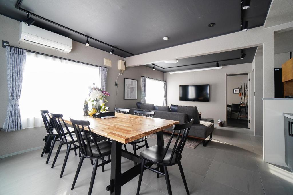 a dining room and living room with a wooden table and chairs at Purpure Furano in Kami-furano