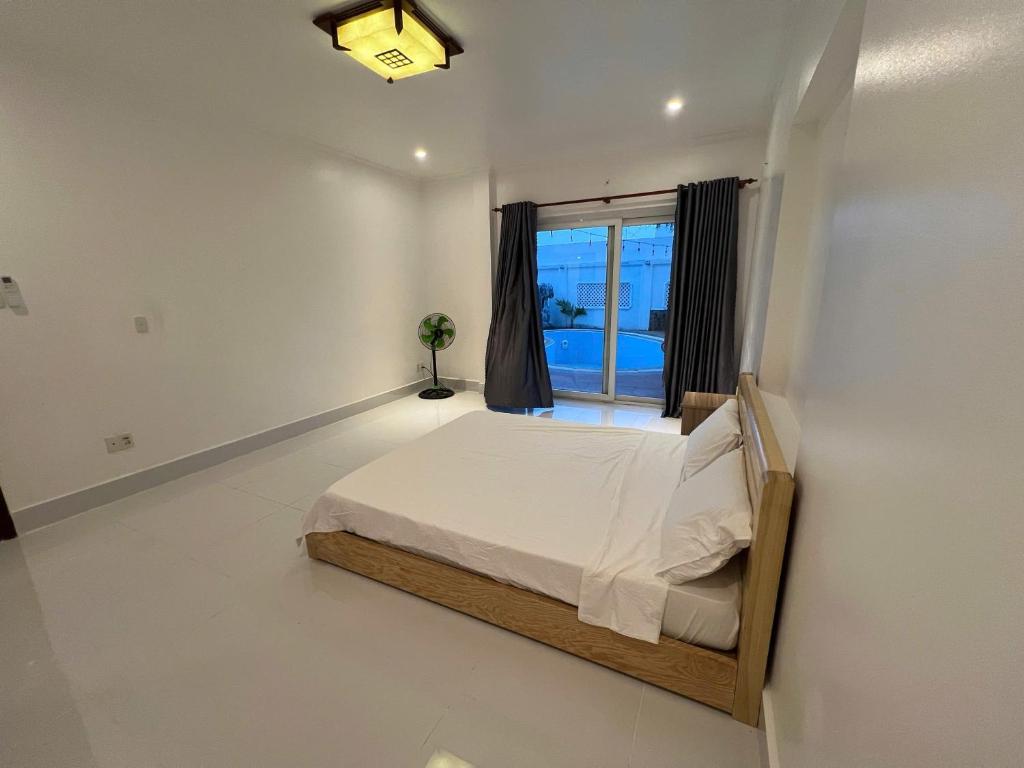 头顿Trần Phú Homestay Vũng Tàu - View biển bãi trước - 7 phòng ngủ lớn - Hồ bơi riêng的带床和窗户的卧室
