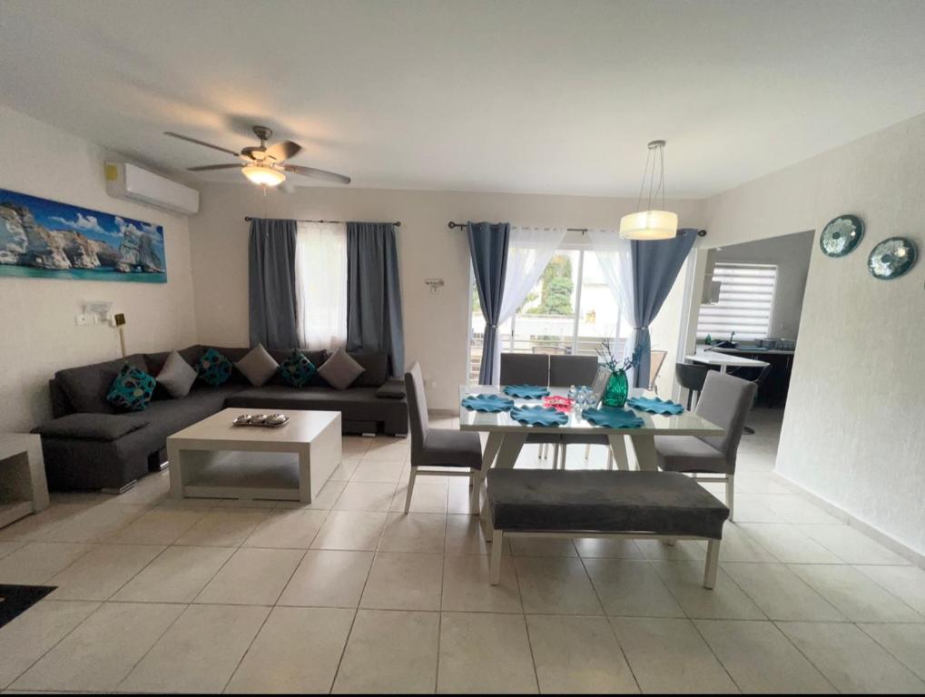 ein Wohnzimmer mit einer Couch und einem Tisch und Stühlen in der Unterkunft Departamento Blue Vacacional in Playa del Carmen