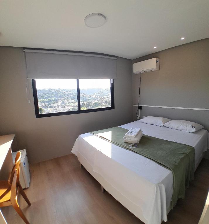a bedroom with a large bed with a window at Zuppolini Garden Hotel in Bananeiras