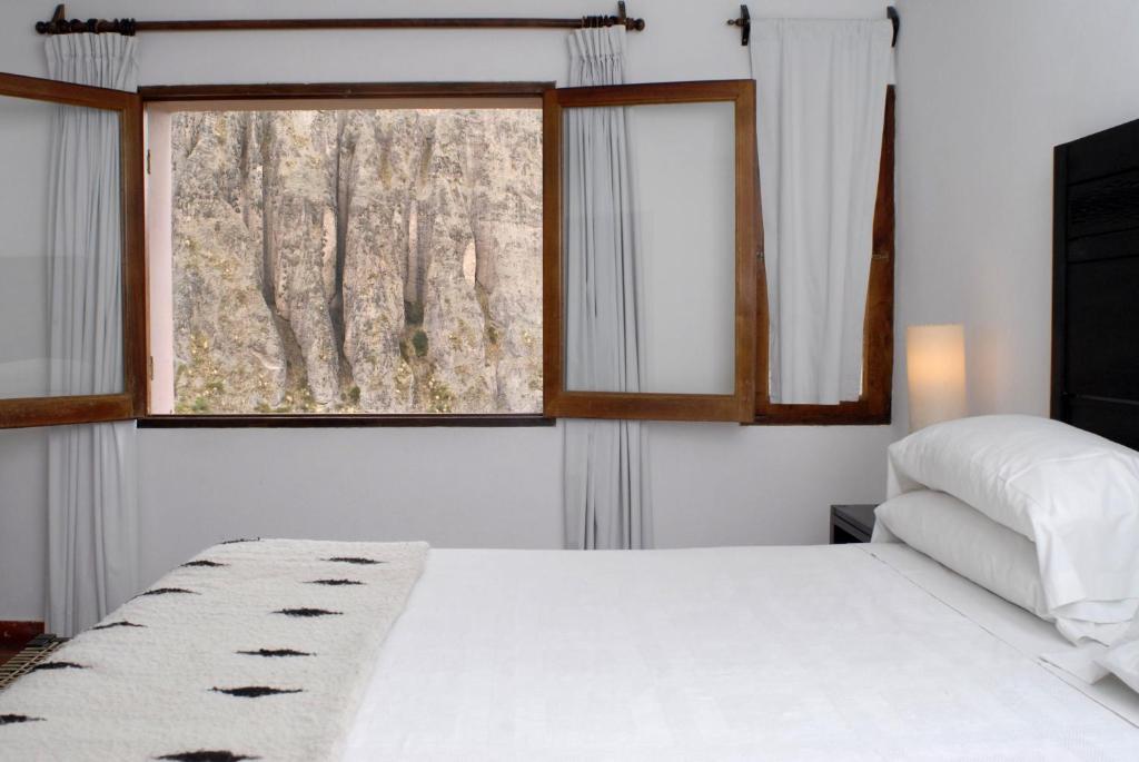 a bedroom with a white bed and a window at Hotel Iruya in Iruya