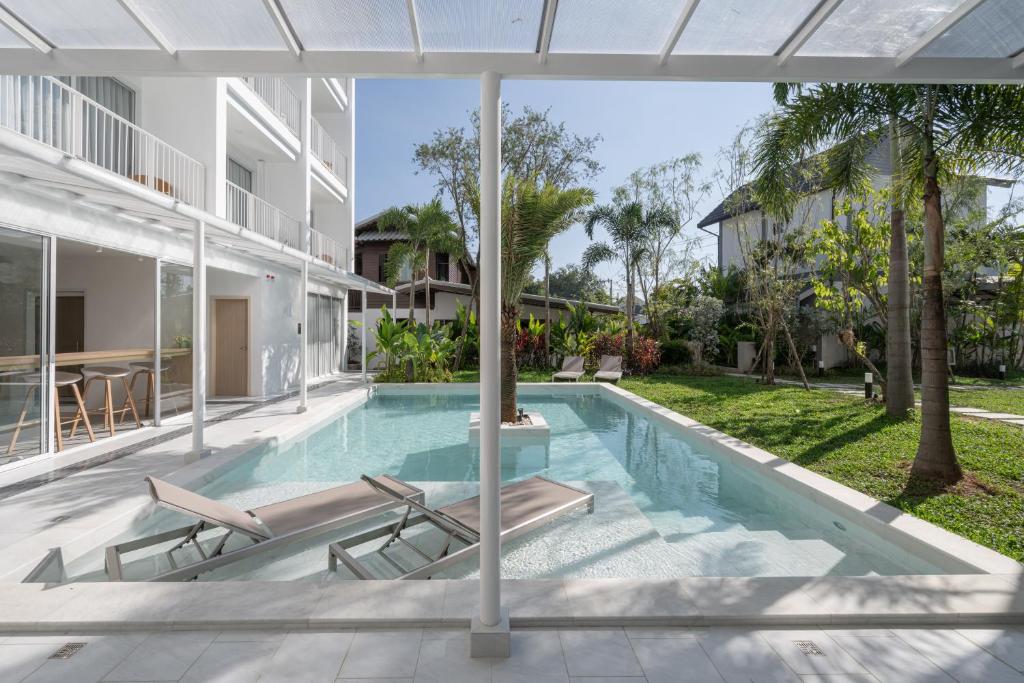 A covered terrace overlooks the courtyard pool, with loungers partly in the shallow water.
