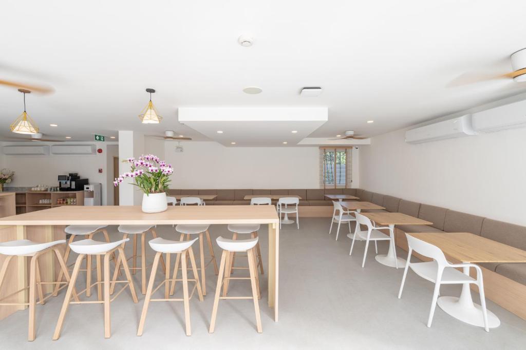 A bright communal dining room offers a long counter, stools and upholstered bench seating.