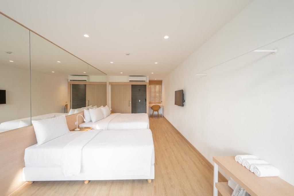 A spacious twin room with mirrored wardrobes, timber flooring and a towel shelf.