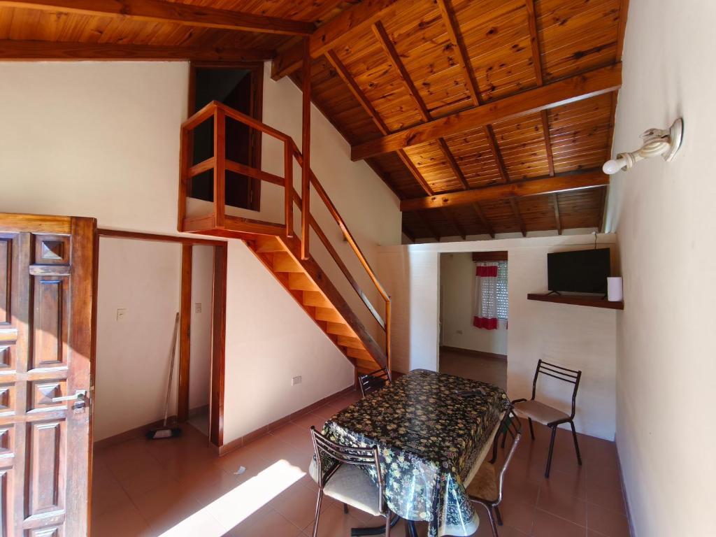a dining room with a table and a staircase at Chalet Mar de Ajo in Mar de Ajó