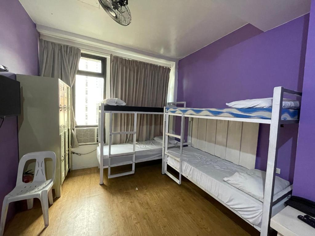 マニラにあるThe Purple Tree Hostelの紫の壁の客室で、二段ベッド2組が備わります。