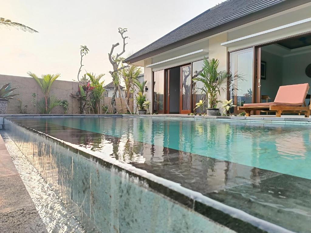 a swimming pool in front of a house at 2BR Ubud private pool kitchen in Ubud
