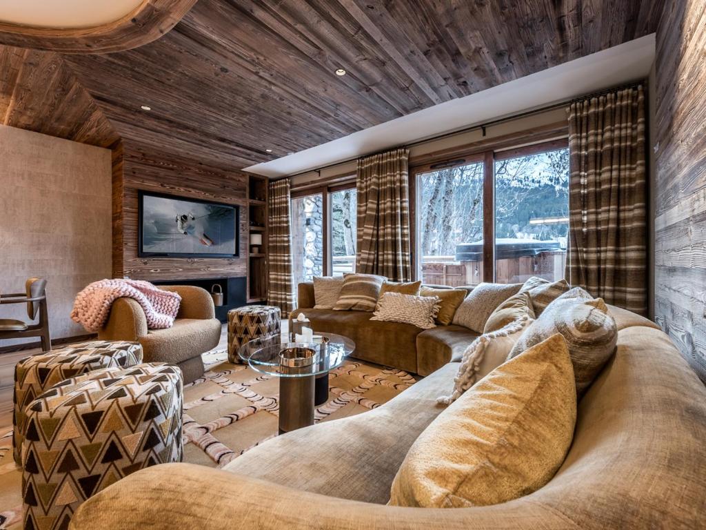 - un grand salon avec un grand canapé et des chaises dans l'établissement Chalet luxueux avec sauna, home cinéma et bain norvégien - FR-1-613-127, à Les Allues