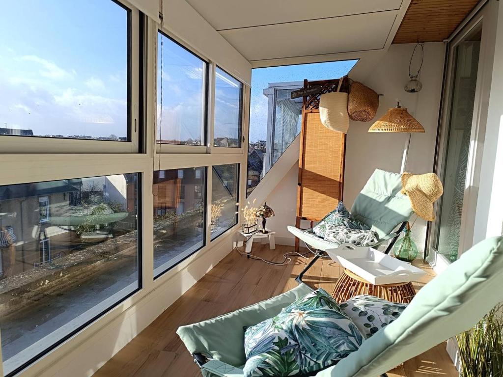 d'un balcon avec une chaise, une table et des fenêtres. dans l'établissement Bel appartement 4 pers avec parking et WIFI au centre-ville de Perros-Guirec - FR-1-368-454, à Perros-Guirec