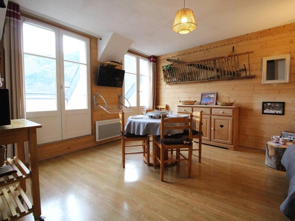 une salle à manger avec une table et une cuisine dans l'établissement Duplex centre Luchon 4 pers, balcons, parking privé - FR-1-313-239, à Luchon