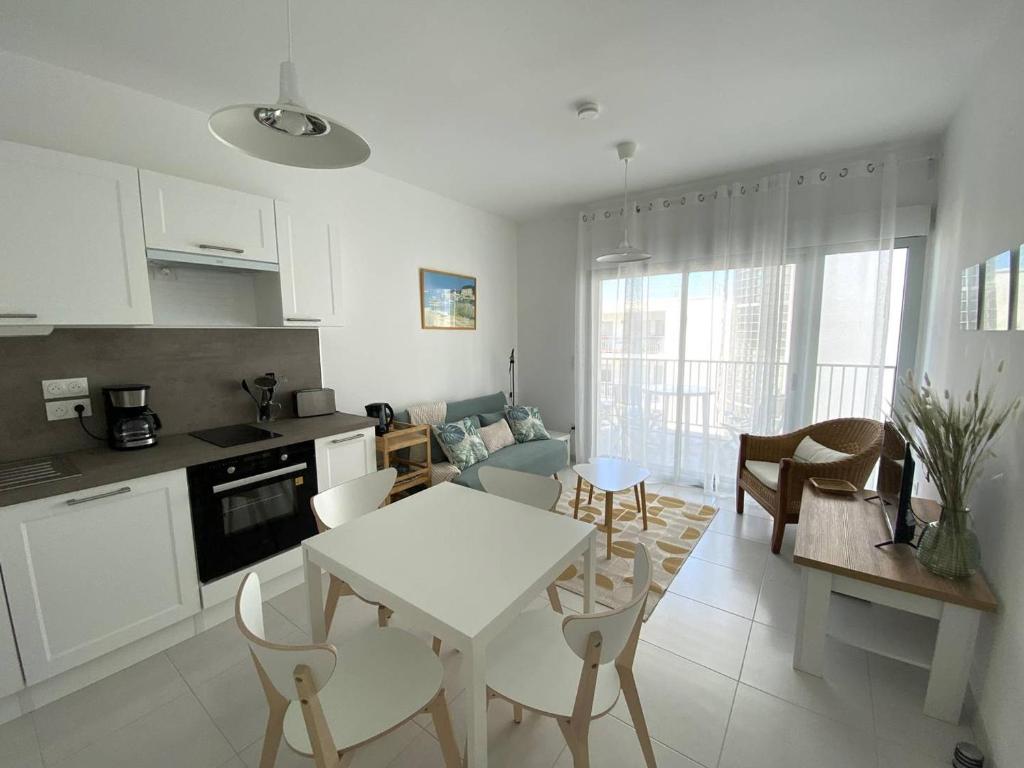 une cuisine et un salon avec une table et des chaises dans l'établissement Royan T2 2* avec Balcon et Parking à 250m de la Plage - FR-1-738-37, à Royan