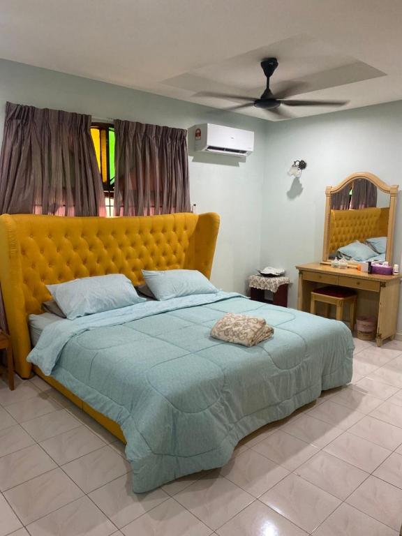 a bedroom with a large bed with a yellow headboard at Seri Selasih Klebang! in Malacca