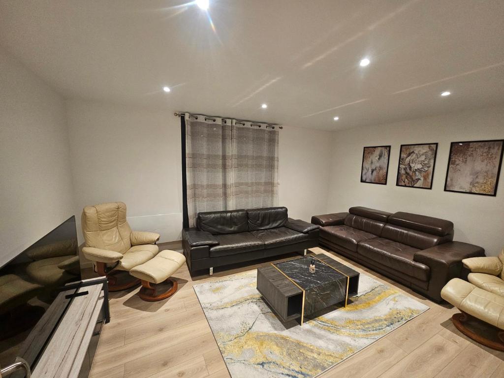 - un salon avec un canapé et des fauteuils en cuir noir dans l'établissement Appartement 75m2 neuf 15 min centre ville, à Reims
