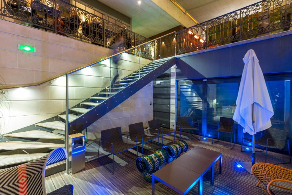 a staircase in a building with a table and a umbrella at Hotel C2 in Marseille