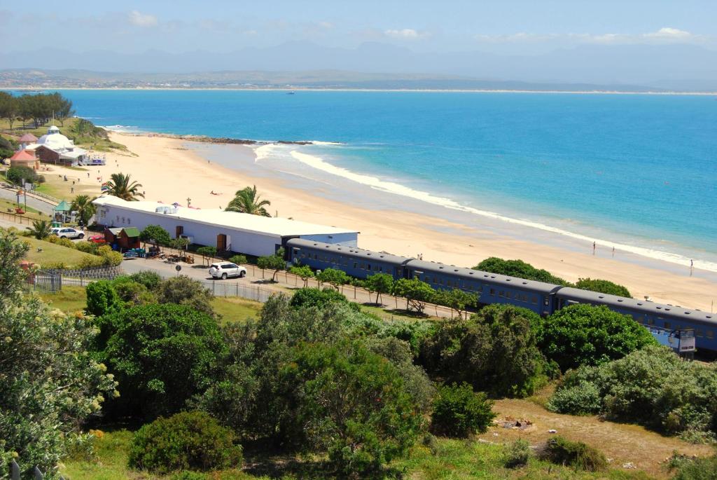 a train is parked next to a beach at Santos Express in Mossel Bay