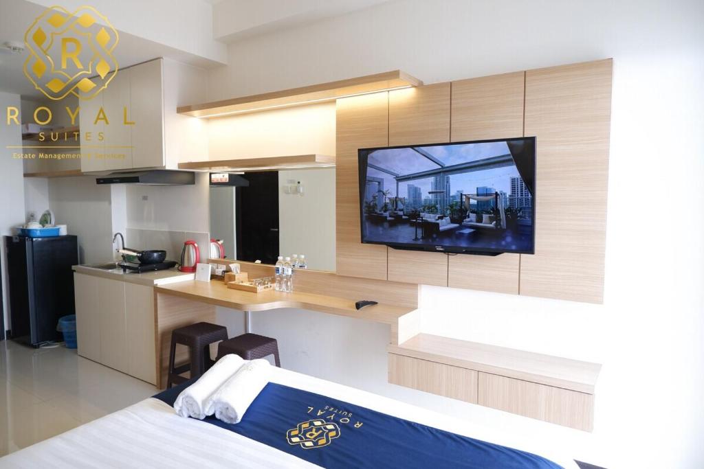 a room with a kitchen and a tv on a wall at Royal Suites Studio 17th Floor - Citra Plaza Nagoya Apartment in Jodoh