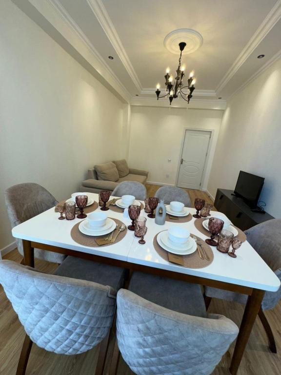 a dining room with a white table and chairs at Paradise- 2 rooms in Sumqayyt
