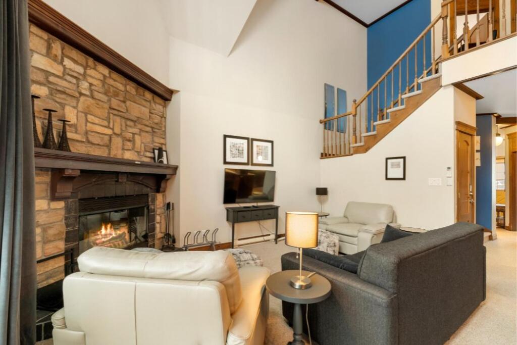 a living room with a couch and a fireplace at Les Manoirs 3bdrs Near Village in Mont-Tremblant