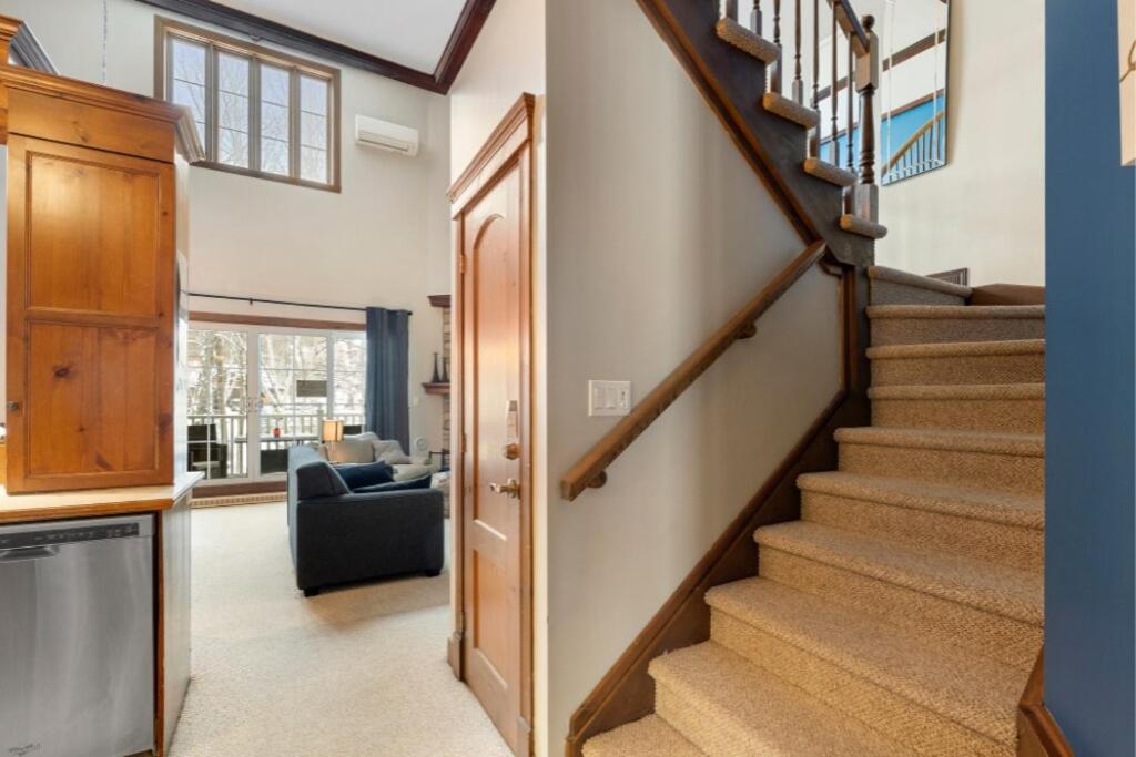 a hallway with a staircase in a house at Les Manoirs 3bdrs Near Village in Mont-Tremblant