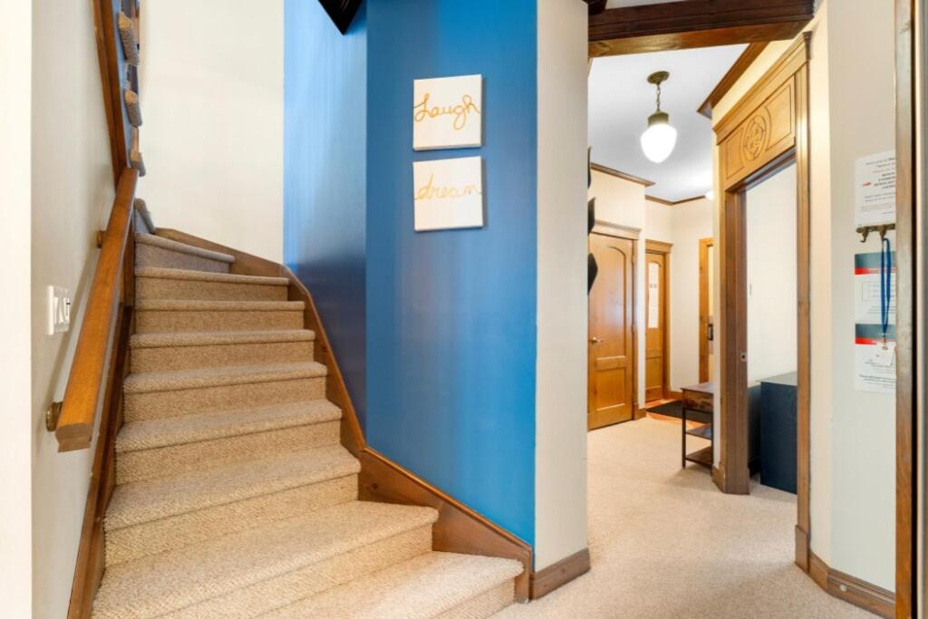 a staircase in a hallway with a blue wall at Les Manoirs 3bdrs Near Village in Mont-Tremblant