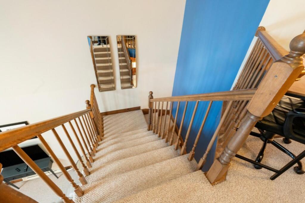 a wooden staircase in a room with a blue wall at Les Manoirs 3bdrs Near Village in Mont-Tremblant