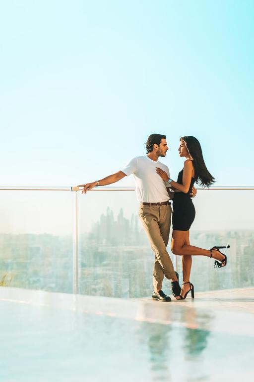 a man and a woman standing on top of a building at FIVE Jumeirah Village in Dubai