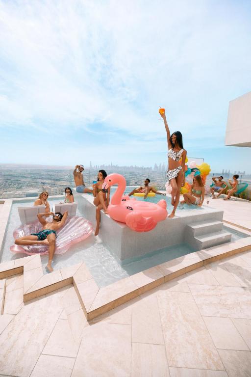 a group of people sitting around a pool at FIVE Jumeirah Village in Dubai