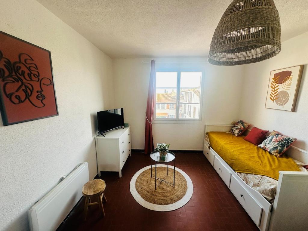 a small room with a bed and a television at Studio en plein cœur du village in Saintes-Maries-de-la-Mer