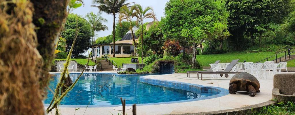 a swimming pool in front of a house at Royal Palm Galapagos, Curio Collection Hotel by Hilton in Bellavista