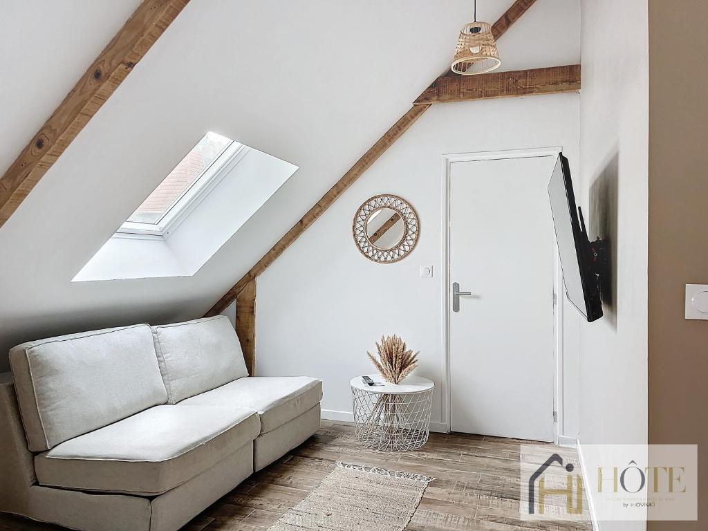 a living room with a white couch and a skylight at Le Cosy - 50m de la plage in Bray-Dunes