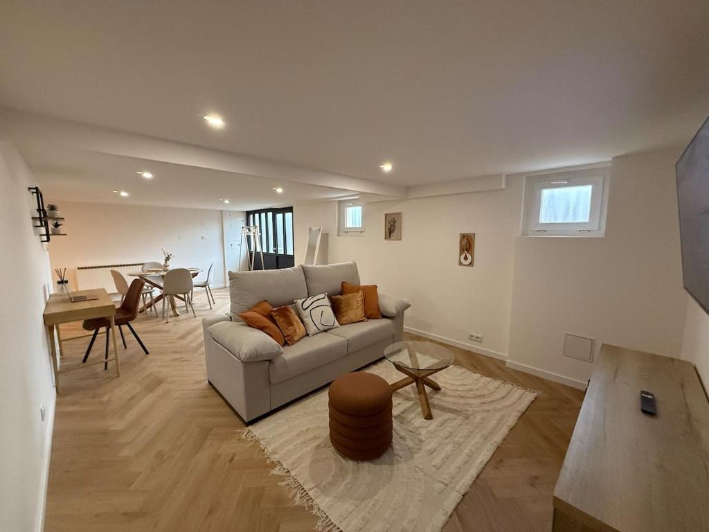a living room with a couch and a table at Logis en campagne avec piscine in Châlonvillars
