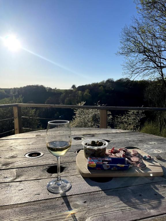 un verre de vin blanc assis sur une table en bois dans l'établissement Le petit cocon à la campagne, à Beuzevillette