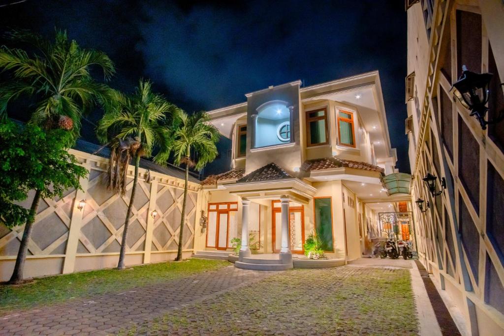 una grande casa con palme di fronte di Hotel Permata Malioboro a Yogyakarta