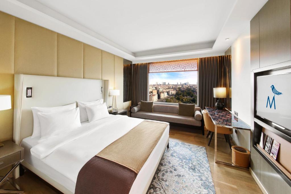 a bedroom with a large bed and a living room at The Marmara Taksim in Istanbul