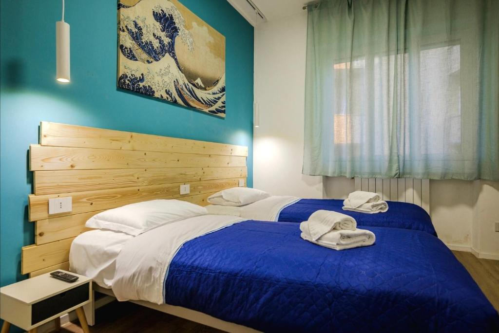 Hotel The Rooms 5 min to Rho-Fiera Milano, two beds in a bedroom with blue walls at The Rooms 5 min to Rho-Fiera Milano in Pero