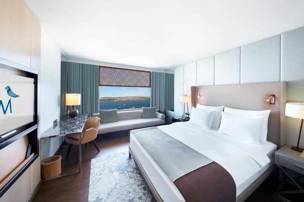 a hotel room with a large bed and a couch at The Marmara Taksim in Istanbul