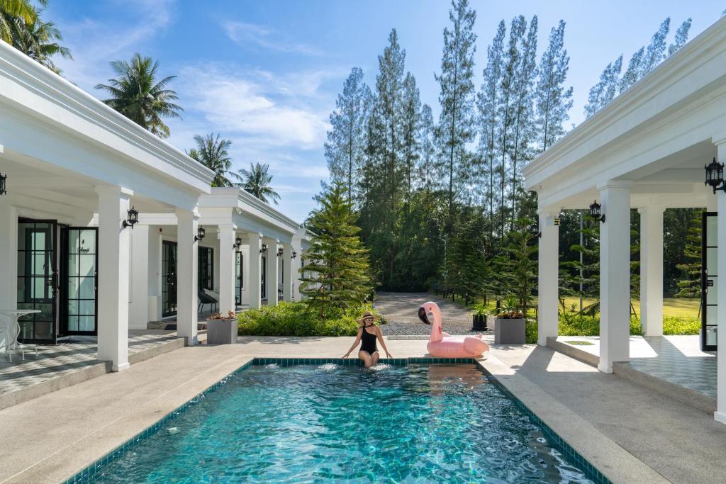 two girls sitting on pink flamingos in a swimming pool at Tarn Villa Krabi in Krabi