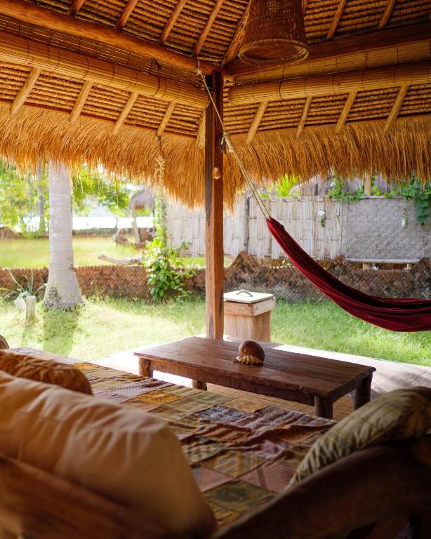 a hammock in a pavilion with a hammock at Gili Asahan Eco Lodge & Restaurant in Gili Asahan