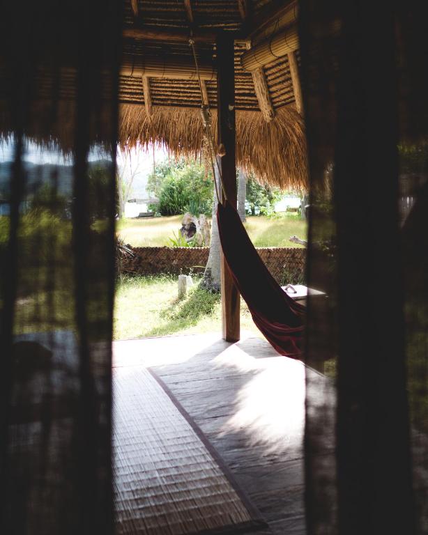 a hammock hanging from a straw hut at Gili Asahan Eco Lodge & Restaurant in Gili Asahan