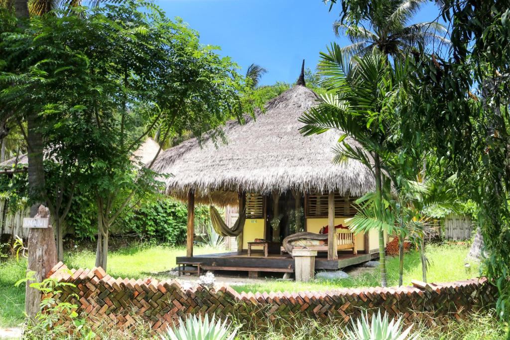 a small hut with a thatched roof in a yard at Gili Asahan Eco Lodge & Restaurant in Gili Asahan